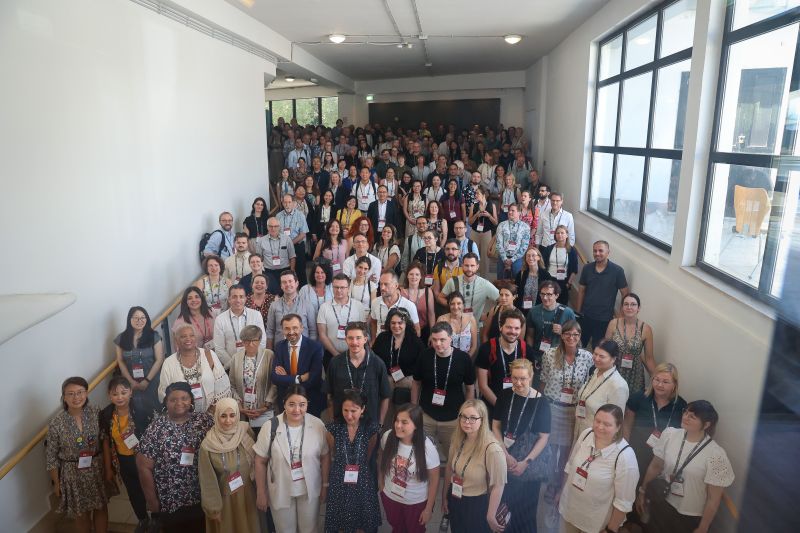 Delegates who attended the IRC posed along a staircase by a window