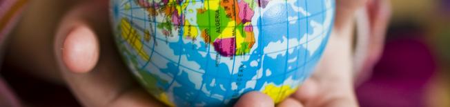 Child's hand holding globe